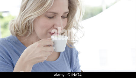 Close up on a mature woman is drinking a coffee Stock Photo