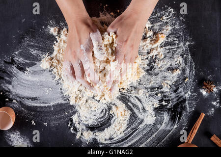 Making of cookies with ingredients like eggs, flour, cinnamon, anise, rolling pin, paper on blackboard Stock Photo