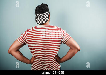 A young man is wearing a striped shirt and a checkered cap Stock Photo