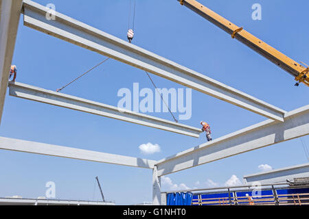 Height worker is high up on concrete frame without proper safety equipment. Stock Photo