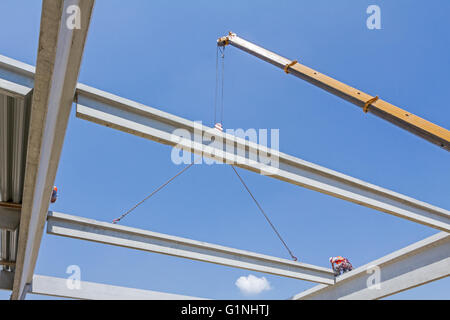 Height worker is high up on concrete frame without proper safety equipment. Stock Photo