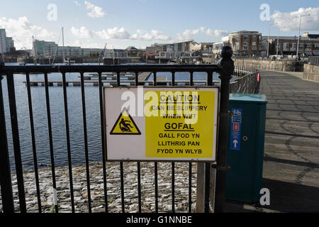 Caution slippery when wet sign in Cardiff Bay Wales UK Stock Photo