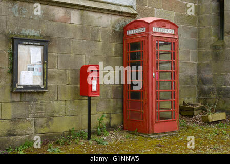 A red post box and red telephone box in the centre of Harthill village in Cheshire UK Stock Photo