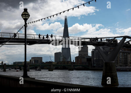 Silhouette of the Shard and people crossing the Millennium Bridge London UK Stock Photo