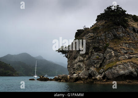 Mist and rain surround Kiwiriki Bay anchorage within Port Fitzroy, with boats at anchor, Great Barrier Island. New Zealand Stock Photo