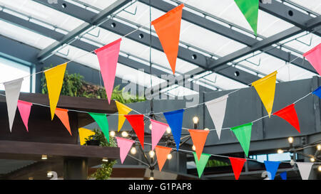 Multi colored triangle flags hanging indoor party Stock Photo