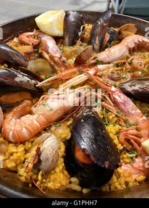 A traditional Spanish Seafood Paella dish with an assortment of fish such as mussels, clams and prawns. Stock Photo