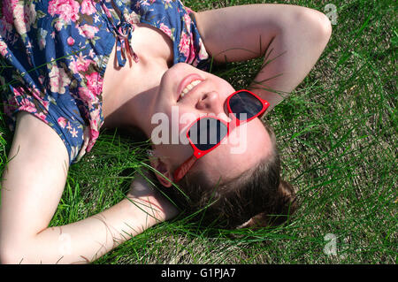 Girl lying on the grass and looking at the sky Stock Photo