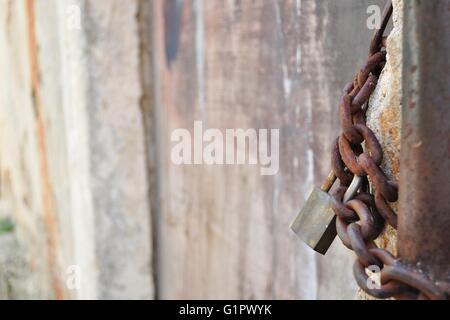 Detail of old, rusty padlock and metal chain. Space in left Stock Photo