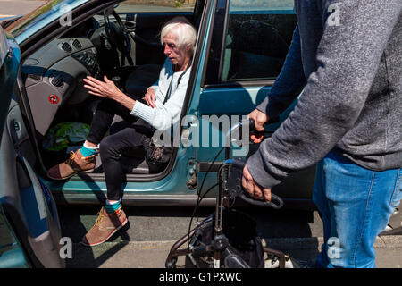 An Elderly Disabled Woman Getting Out Of A Car, Brighton, Sussex, UK Stock Photo