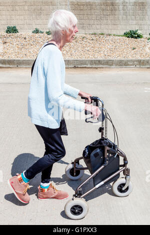An Elderly Disabled Woman Using A Rollator Walking Aid, Brighton, Sussex, UK Stock Photo