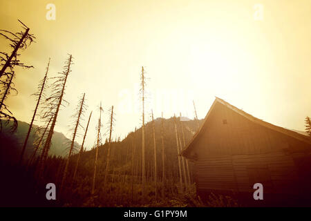 Mountains abstract nature landscape. Wooden house in mountains. Stock Photo
