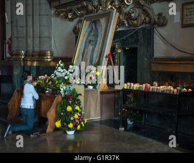 Praying woman in Basilika Santa Maria de Guadelope, Mexico Stock Photo