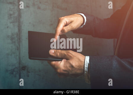 Businessman using digital tablet, finger pressing touch screen of modern electronic device. Stock Photo