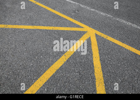 Yellow dividing lines on dark asphalt, abstract road marking background photo texture Stock Photo