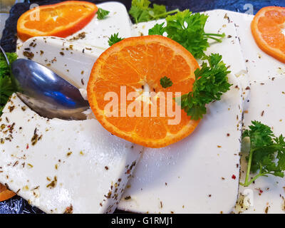 Colorful orange slice and parsley on creamy feta cheese Stock Photo