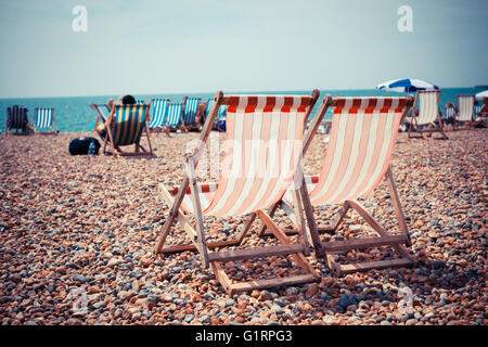 Two deck chairs on a pebble beach Stock Photo