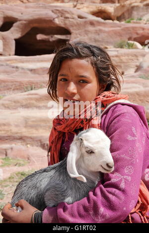 Portrait of a little Bedouin girl with her little goat in Petra – Jordan Stock Photo