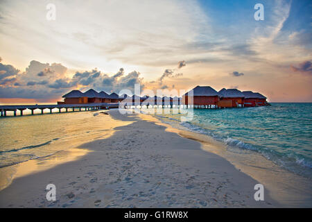 bungalow build on the sea in the sunset light, one of Maldives island Stock Photo