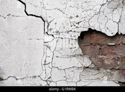Old cracked wall background showing bricks underneath Stock Photo