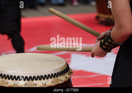 Japanese artist playing on traditional taiko drums Stock Photo