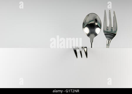 Metal spoon and two forks formed into conceptual fantasy figure Stock Photo