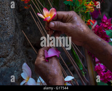 Salvadoran Woman decorates palm fronds with flowers during the Flower & Palm Festival in El Salvador Stock Photo