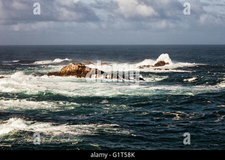 Crashing waves and high surf pound offshore Seal Lion Rocks at Point Lobos State Natural Reserve on California’s Big Sur coast. Stock Photo