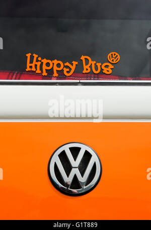 Orange VW Volkswagen camper van rear end with a hippy bus sticker in the window Stock Photo