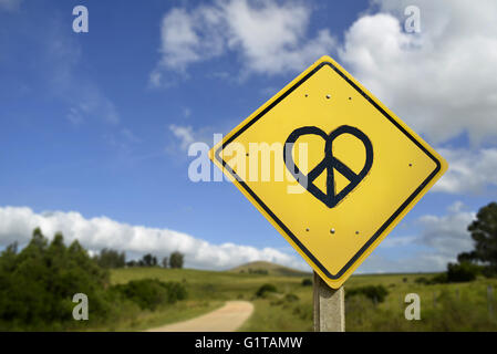 Way to peace and love, inspirational hope concept. Road sign with heart shape hippie symbol in nature environment, includes copy Stock Photo