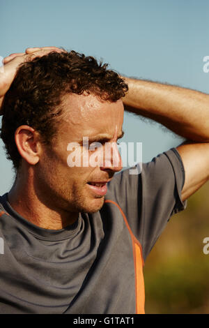 Close up male runner with hands behind head Stock Photo