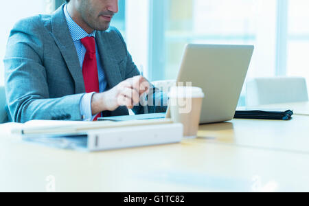 Focused businessman working at laptop in conference room Stock Photo