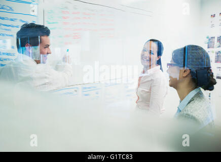 Business people brainstorming at whiteboard in office Stock Photo