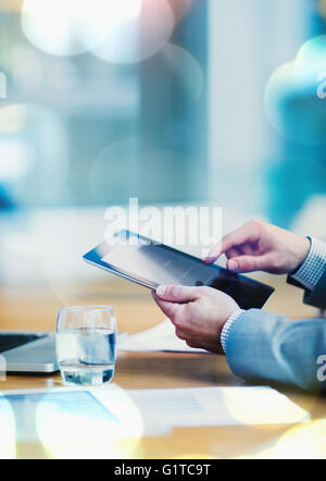 Businessman using digital tablet at conference table Stock Photo