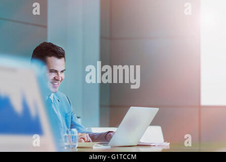 Businessman working at laptop in conference room Stock Photo