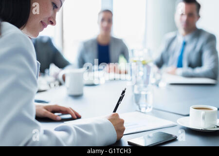 Businesswoman reviewing paperwork in conference room meeting Stock Photo