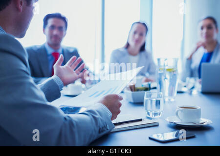 Businessman leading meeting explaining paperwork in conference room Stock Photo