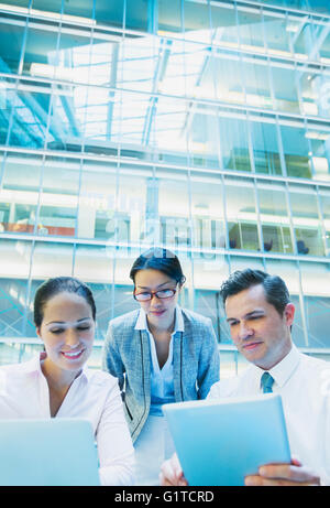 Business people using laptop and digital tablet in office atrium Stock Photo
