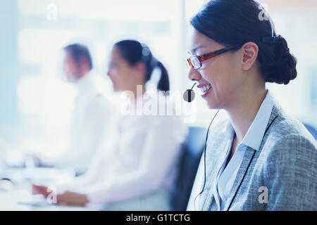 Smiling businesswoman talking on the phone with headset Stock Photo