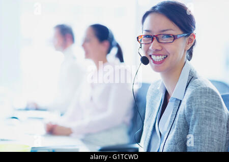 Portrait of smiling businesswoman talking on the phone with headset Stock Photo