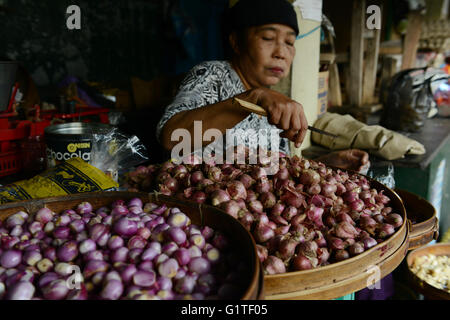 A Javanese woman peeling shallots in a market in Yogyakarta. Stock Photo