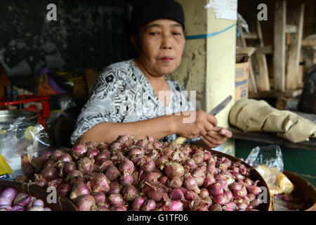 A Javanese woman peeling shallots in a market in Yogyakarta. Stock Photo