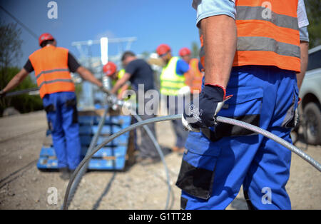 Workers splice the control wire for the cable car at the construction site for the International Garden Show (IGA) in Berlin, Germany, 18 May 2916. Starting spring 2017, gondolas will ride along the 1.5km-long route at a height of 30 meters. Photo: Britta Pedersen/dpa Stock Photo