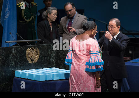 (160519) -- UNITED NATIONS, May 19, 2016 (Xinhua) -- UN Secretary-General Ban Ki-moon(R) presents the 'Captain Mbaye Diagne Medal for Exceptional Courage' to Ms. Yacin Mar Diop, the widow of Captain Diagne, on the occasion of the International Day of United Nations Peacekeepers, at the United Nations headquarters in New York, United States, May 19, 2016. The late Captain Diagne, a Senegalese military officer, saved hundreds of lives while serving as a peacekeeper during the 1994 Rwandan Genocide. The United Nations on Thursday honored fallen UN peacekeepers who lost their lives while serving u Stock Photo