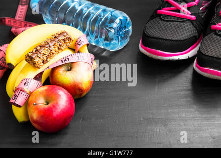 Heathy lifestyle with training shoes, fruits, cereal bar, water bottle Stock Photo