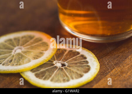 perspective view of black tea with lemon in cup and on wooden plank table Stock Photo
