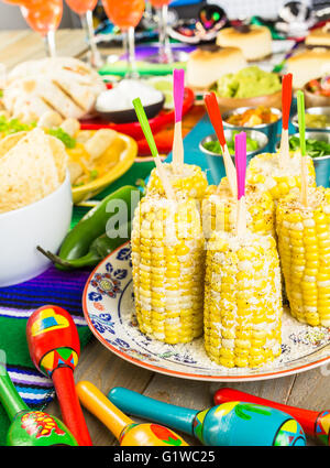 Fiesta party buffet table with spicy mexican corn on the cob and other traditional Mexican food. Stock Photo