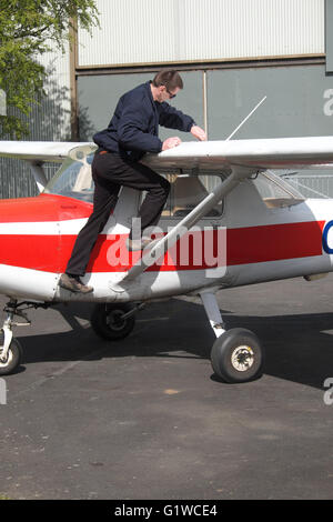 Pilot checks the wing fuel tanks of a flying club Cessna 152 in the UK Stock Photo