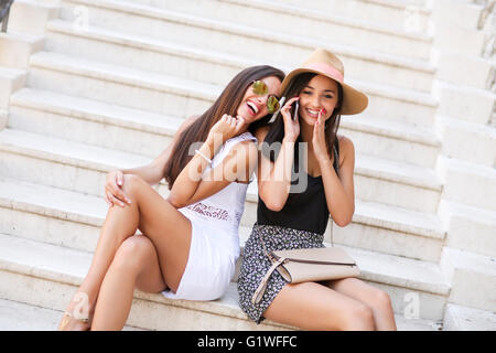 Two women sitting on the stairs outside Stock Photo