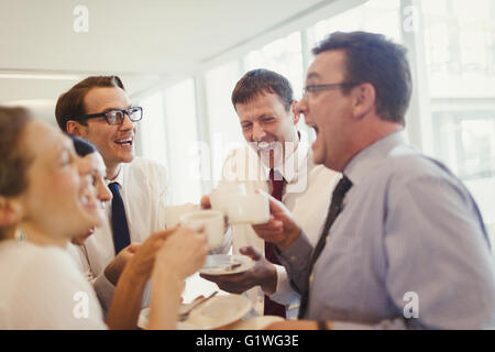 Business people laughing and drinking coffee in office Stock Photo